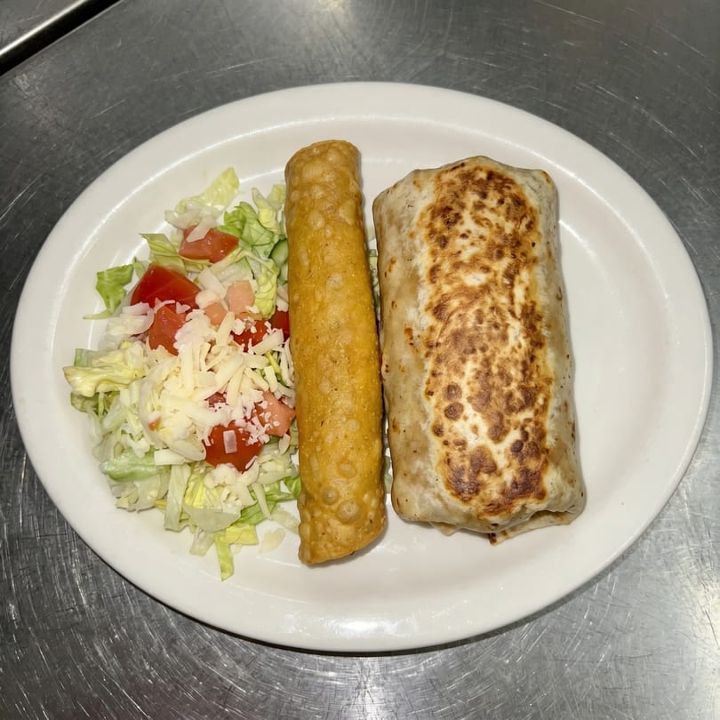 A plate with a burrito, a taquito, and a side salad with shredded cheese and tomatoes.